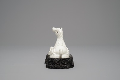 Un mod&egrave;le d'un cheval en porcelaine blanc de Chine de Dehua sur socle sculpt&eacute;, Kangxi