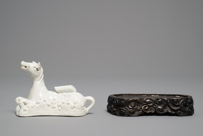 Un mod&egrave;le d'un cheval en porcelaine blanc de Chine de Dehua sur socle sculpt&eacute;, Kangxi