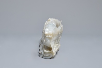 A Chinese white jade group with boys on a raft on carved wooden base, Qing