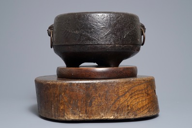 A Japanese relief-decorated cast iron furogama on wooden stand, Edo/Meiji, 18/19th C.