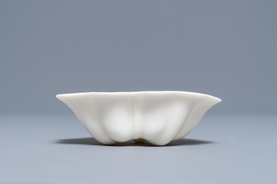 A Chinese Dehua blanc de Chine lotus leaf-shaped brush washer on stand, Kangxi
