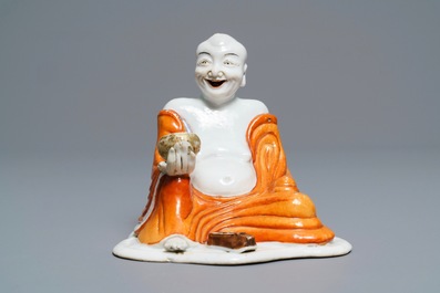 A Chinese iron red decorated figure of a Luohan, Qianlong