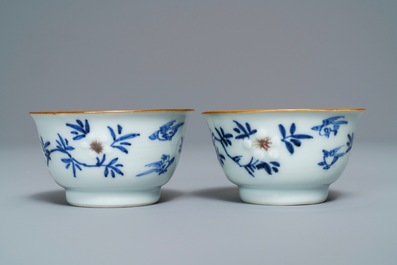 A pair of Chinese blue, white and underglaze red cups and saucers, Kangxi