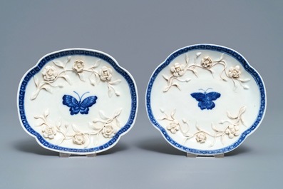 Een paar Chinese blauwwitte 'soft paste' koppen en schotels met reli&euml;fdecor, Qianlong