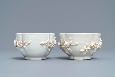 Een paar Chinese blauwwitte 'soft paste' koppen en schotels met reli&euml;fdecor, Qianlong