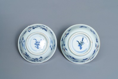 A pair of Chinese blue, white and underglaze red cups and saucers, Kangxi