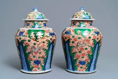 A pair of Chinese wucai 'galloping horses' vases and covers, Transitional period