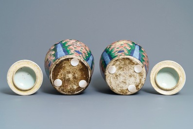 A pair of Chinese wucai 'galloping horses' vases and covers, Transitional period