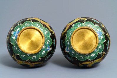 A pair of Chinese cloisonn&eacute; bottle vases, two silver saucers and a silver cup, 19/20th C.
