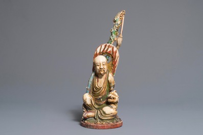 A polychrome Chinese ivory group of a sage with a tiger, 19/20th C.
