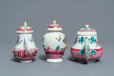 A Chinese famille rose relief-decorated teapot, milk jug and tea caddy on stands, Yongzheng