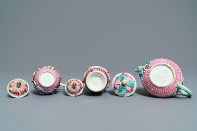 A Chinese famille rose relief-decorated teapot, milk jug and tea caddy on stands, Yongzheng