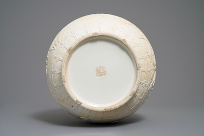 A Chinese monochrome cream-glazed relief-decorated hu vase, Qianlong mark, 20th C.