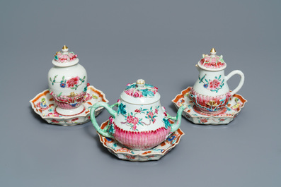 A Chinese famille rose relief-decorated teapot, milk jug and tea caddy on stands, Yongzheng