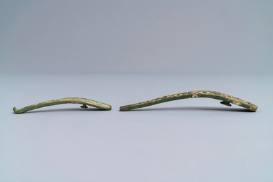 Two Chinese inlaid bronze belt hooks and a bronze ornament, Zhou or Han