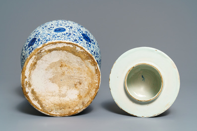 A Dutch Delft blue and white three-piece garniture with carved wooden candleholders, 18th C.