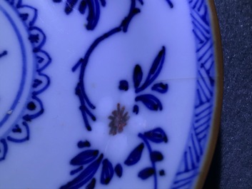 A pair of Chinese blue, white and underglaze red cups and saucers, Kangxi