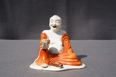 A Chinese iron red decorated figure of a Luohan, Qianlong
