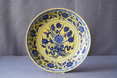 Een Chinees bord met blauwwit boeket van lotusbloemen op gele fondkleur, Qianlong merk, 19/20e eeuw