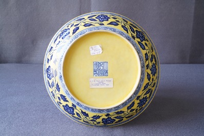 Een Chinees bord met blauwwit boeket van lotusbloemen op gele fondkleur, Qianlong merk, 19/20e eeuw