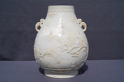 A Chinese monochrome cream-glazed relief-decorated hu vase, Qianlong mark, 20th C.