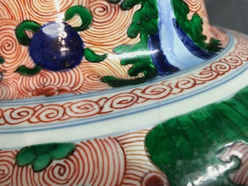 A pair of Chinese wucai 'galloping horses' vases and covers, Transitional period