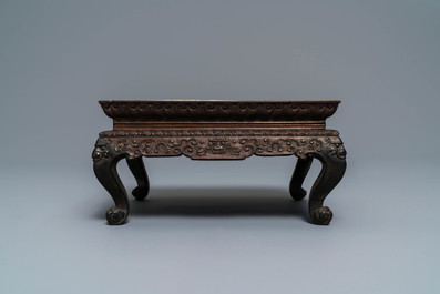 A Chinese carved wooden stand with famille rose plaque, 19th C.