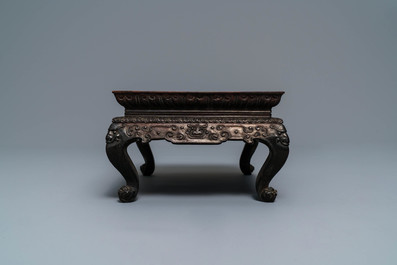 A Chinese carved wooden stand with famille rose plaque, 19th C.