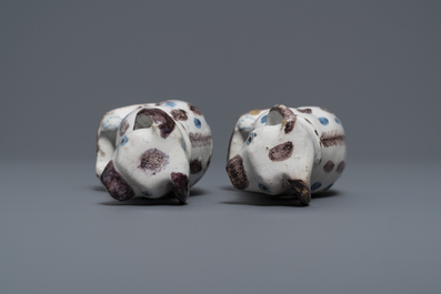 A pair of blue, white and manganese Brussels faience models of dogs, 18th C.