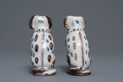 A pair of blue, white and manganese Brussels faience models of dogs, 18th C.