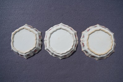 A Chinese famille rose relief-decorated teapot, milk jug and tea caddy on stands, Yongzheng