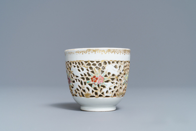 A reticulated Chinese famille rose cup and saucer, Qianlong