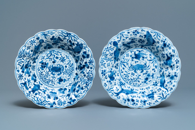 Two Chinese blue and white gadrooned 'crabs and carps' dishes and a pair of plates, Kangxi