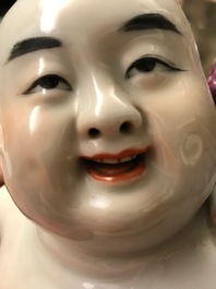 A Chinese famille rose group of two children, impressed marks, Republic, 20th C.