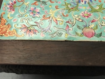 A Chinese carved wooden stand with famille rose plaque, 19th C.