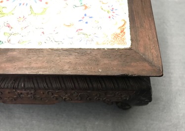 A Chinese carved wooden stand with famille rose plaque, 19th C.