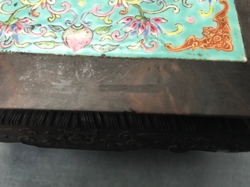 A Chinese carved wooden stand with famille rose plaque, 19th C.