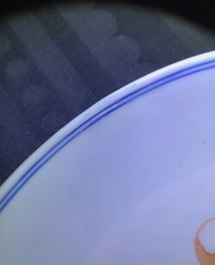 Een Chinees ijzerrood en blauw-wit bord met vleermuizen en perziken, 19e eeuw
