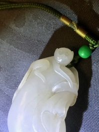 Un pendentif en jade blanc figurant un singe sur une pochette, Qing