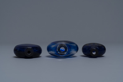 Three Chinese transparent blue glass snuff bottles, one inscribed, 18/19th C.