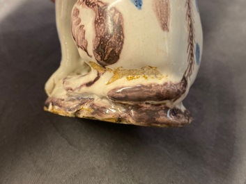 A pair of blue, white and manganese Brussels faience models of dogs, 18th C.