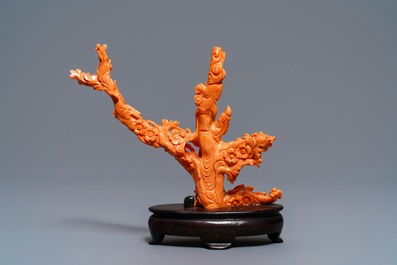 A Chinese carved red coral group of a lady among blossoming branches, 19th C.