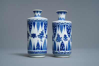 A pair of Chinese blue and white 'Buddhist emblems' rouleau vases, Kangxi