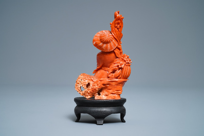 A Chinese carved red coral group of a boy with a parrot, 19/20th C.