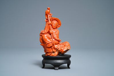 A Chinese carved red coral group of a boy with a parrot, 19/20th C.