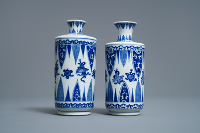 A pair of Chinese blue and white 'Buddhist emblems' rouleau vases, Kangxi