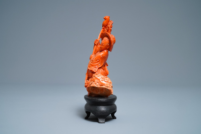 A Chinese carved red coral group of a boy with a parrot, 19/20th C.