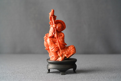 A Chinese carved red coral group of a boy with a parrot, 19/20th C.