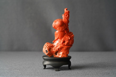 A Chinese carved red coral group of a boy with a parrot, 19/20th C.