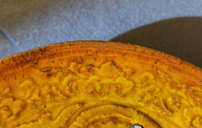 Une assiette en gr&egrave;s porcelaineux &agrave; couverte ambre &agrave; d&eacute;cor en relief, Liao (916-1125)